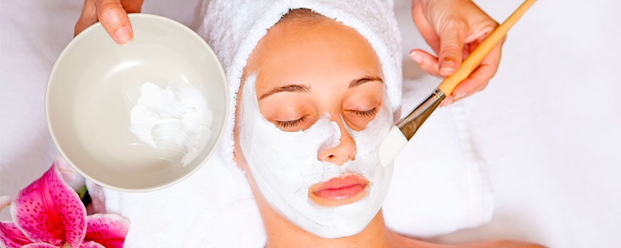 Primer plano de mujer recibiendo mascarilla facial de leche.