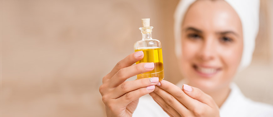 Mujer sosteniendo un frasco con aceite.