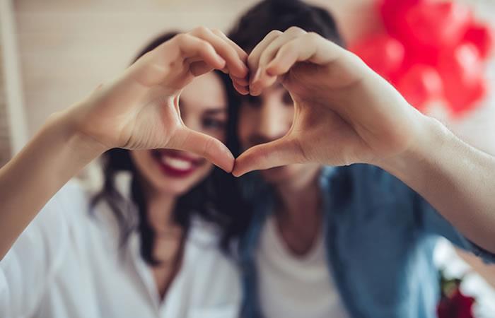 Pareja haciendo  la figura del corazon  con las manos