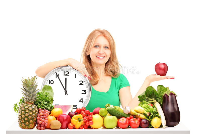 mujer con reloj y frutas