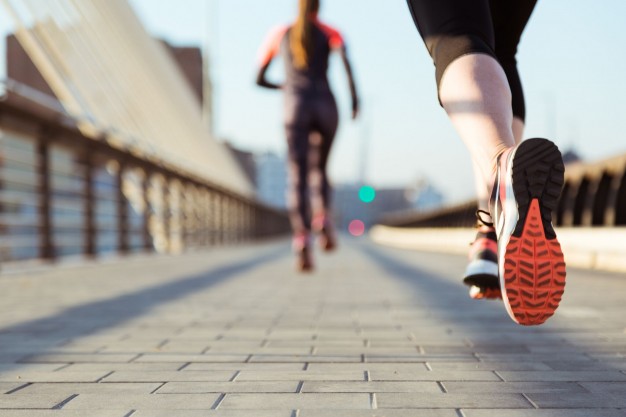 primer plano de pies de una mujer corriendo en la vía.
