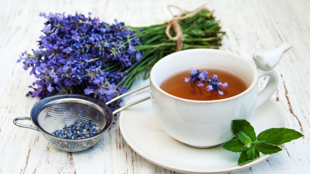 taza con té de lavanda y ramilleta de lavanda a un lado